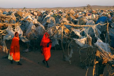 Habillées de vêtements rouges vifs, des femmes traversent le camp d
